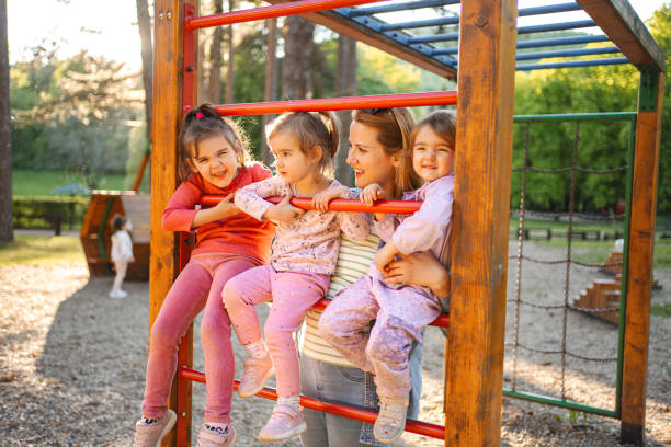 istock Smiling mom with daughters on the playground 2155159699
