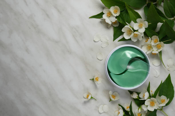istock Under eye patches in jar with spatula on a white marble table. 2155162644