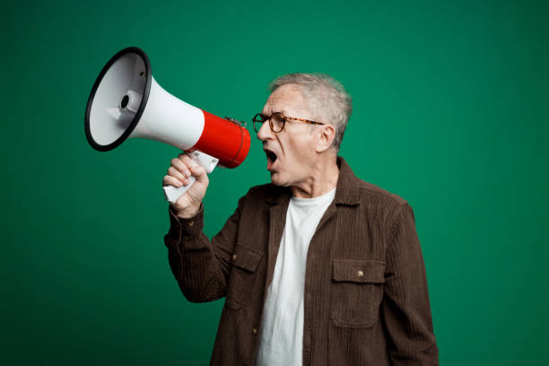 istock Portrait of senior man shouting into megaphone 2155163281