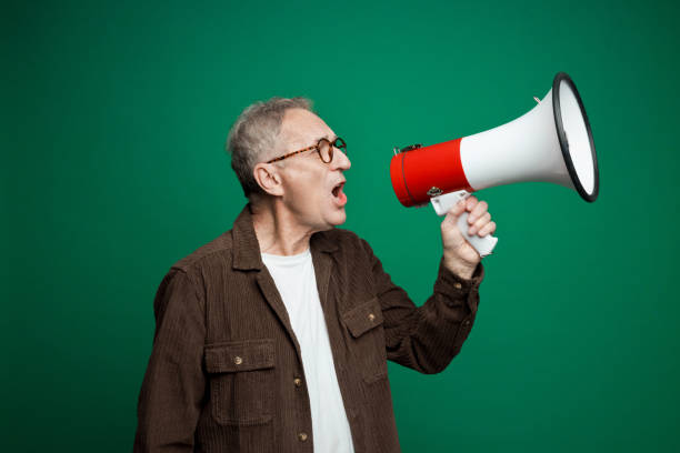 istock Portrait of senior man shouting into megaphone 2155163383
