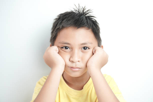 Thoughtful preteen kid boy standing with puzzled serious expression, making choise thinking against white background. Studio shot