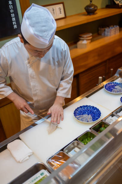istock Chef of traditional Japanese restaurant slicing sashimi in kitchen 2155167217