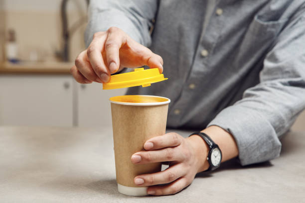 istock Barista Securing Yellow Lid on Takeaway Coffee Cup at Cafe Counter 2155168916