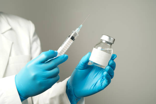 istock doctor or scientist holding a syringe with ampules vaccine, bottle for injection 2155170182