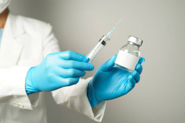istock doctor or scientist holding a syringe with ampules vaccine, bottle for injection 2155170189