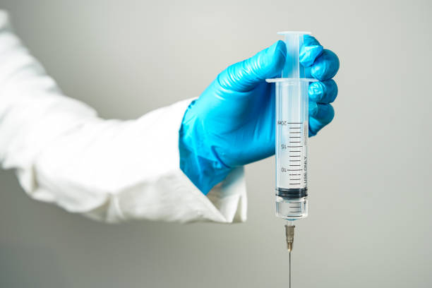 istock doctor or scientist holding a syringe in blue gloves 2155171077