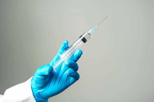 istock doctor or scientist holding a syringe in blue gloves 2155172089