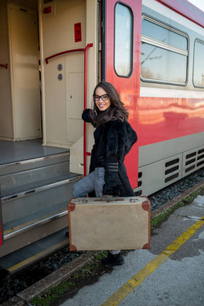 istock Young woman with a big suitcase traveling by a train 2155177992