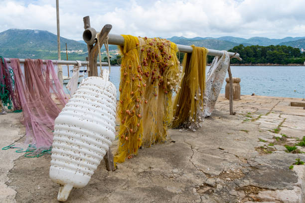 The harbour at Kolocep Island, Croatia.  In the foreground is a fishing net drying on a pier in the harbour.