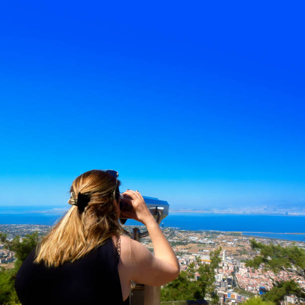 istock Beautiful woman looking at view with coin operated binoculars 2155180773
