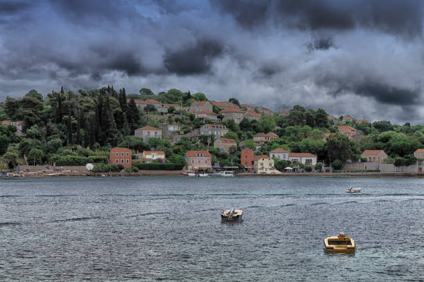 The harbour at Kolocep Island, Croatia.  In the foreground is a rowing boat moored in the harbour.