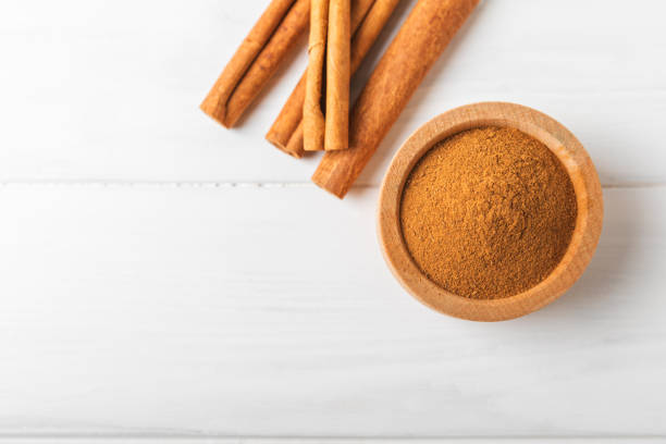 istock Cinnamon powder on a textured wooden background. Spicy spice for baking, desserts and drinks. Fragrant ground cinnamon. Cinnamon stick. Place for text. Copy space. 2155182812