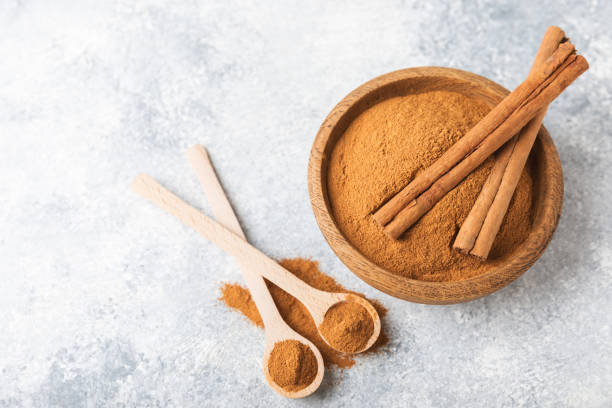 istock Cinnamon powder on a textured wooden background. Spicy spice for baking, desserts and drinks. Fragrant ground cinnamon. Cinnamon stick. Place for text. Copy space. 2155182822