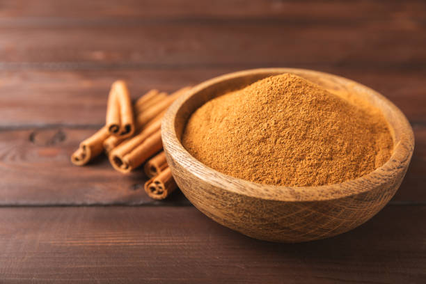 istock Cinnamon powder on a textured wooden background. Spicy spice for baking, desserts and drinks. Fragrant ground cinnamon. Cinnamon stick. Place for text. Copy space. 2155182826