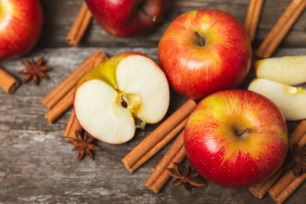 istock Apples with cinnamon on a textured wooden background. Fragrant red spiced apples with cinnamon sticks and star anise. Apple slices with spicy spices. Place for text. Copy space. Harvesting. Fruits. 2155182903