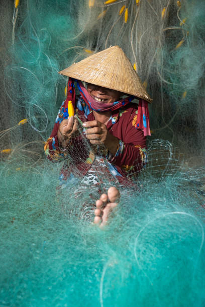 istock Woman knitting turquoise fishing net 2155183131