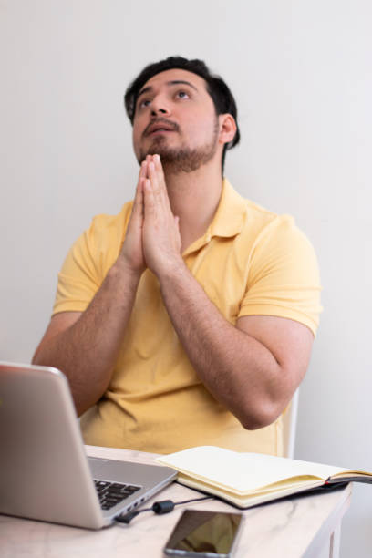 istock Young man praying for solution to the school and the homework front his laptop 2155184676