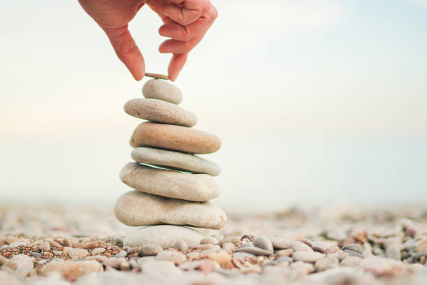 istock A person is holding a rock on top of a stack of rocks 2155186221