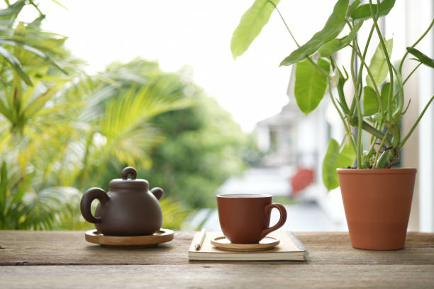 istock Tea cup and earthenware teapot at the balcony and notebooks side view 2155186326