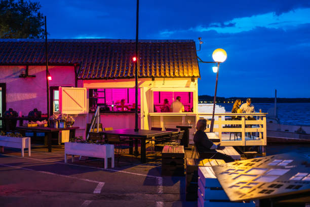 Nida, Neringa, Lithuania - May 25, 2024: People having fun in a summer cafe by the sea at night