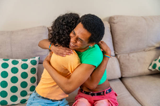 istock Happy romantic gay couple embracing sitting on the sofa 2155187553