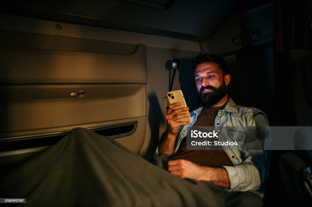 Driver Under Rest A Handsome Truck Driver Using His Phone While He Is Taking A Rest On ...