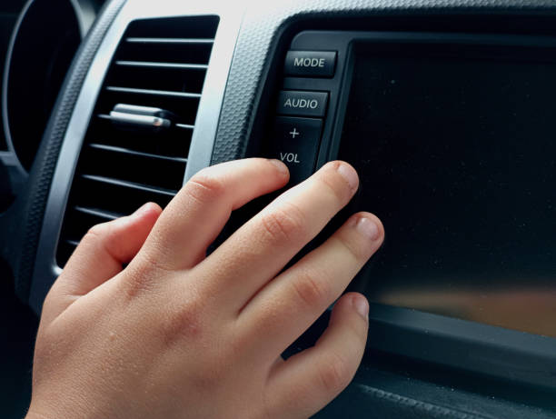 istock A person presses the volume down button on the multimedia device of the car with his finger. The topic of transport and comfort. Listening to music while driving. 2155193879