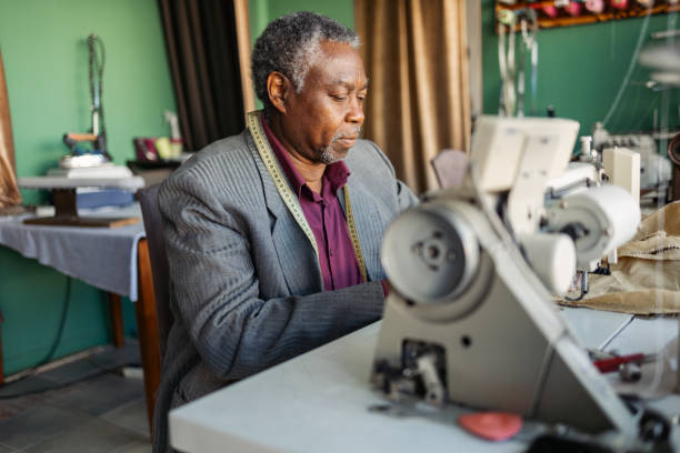 istock Latin senior man working as a tailor. He is working in the small tailoring shop. 2155200615