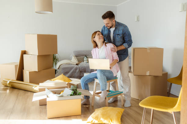 istock Happy couple using laptop in new apartment 2155205098