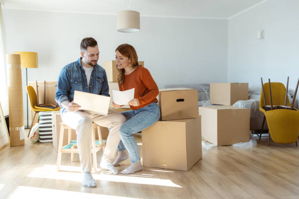 istock Mortgage Application. Happy couple using laptop in their new home 2155207084