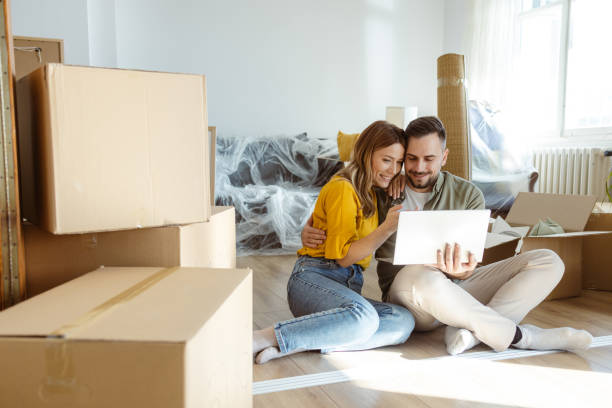 istock Happy couple using laptop in new apartment 2155207443