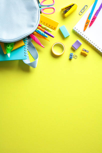 istock Vibrant back to school supplies on yellow background. Flat lay, top view, vertical 2155208588