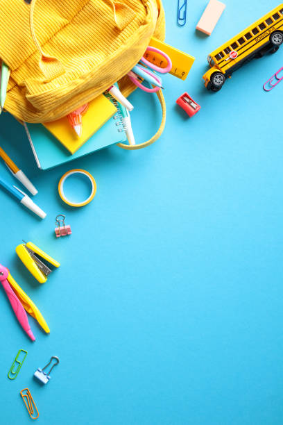 istock Back to school concept. Yellow backpack with colorful school supplies on blue background. Flat lay, top view. 2155208862