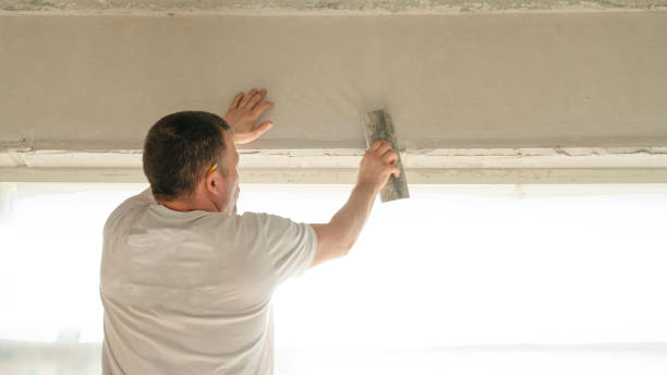 istock Worker is putting a gypsum plaster on a wall using a spatula. 2155211520
