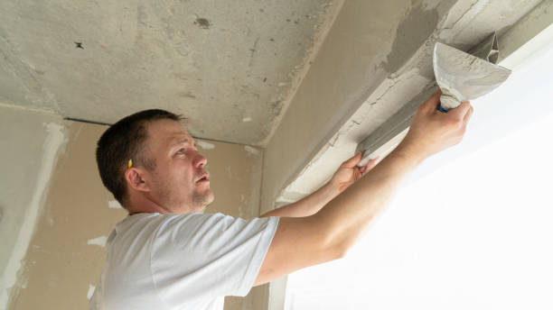 istock Worker is putting a gypsum plaster on a wall using a spatula. 2155212901