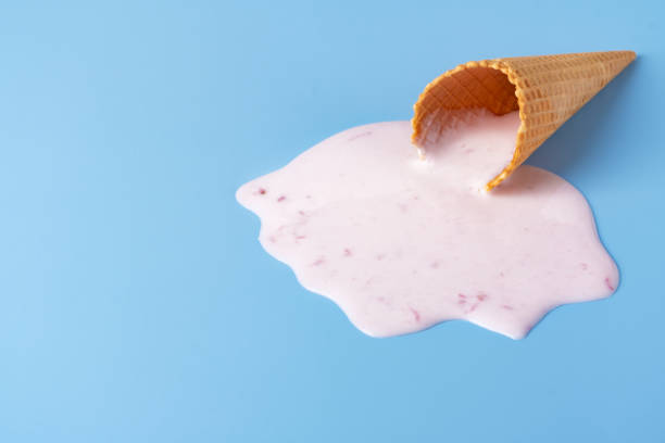 istock Pink ice cream melting and spilling from the waffle cone. 2155215772