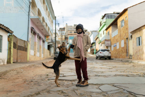 istock Boy playing with dog on the street 2155219167