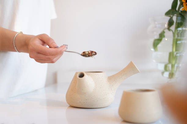 istock Woman preparing herbal tea in ceramic teapot 2155220511