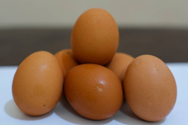 Natural homemade chicken eggs. Several eggs on a white background. Top view. With a shadow, food stock, stock photo.