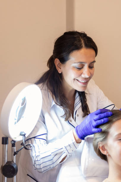 istock Dermatologist examining her patient's scalp 2155224542