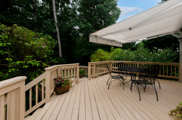 Wooden Deck with Awning and Patio Furniture A spacious wooden deck with an awning, outdoor furniture, surrounded by lush greenery house railing stock pictures, royalty-free photos & images