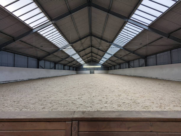 Empty spacious riding arena for riding or training horses. Indoor equestrian place