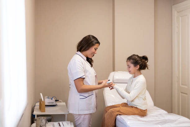 istock Pediatric dermatologist examining a girl patient with a dermatoscope 2155226000