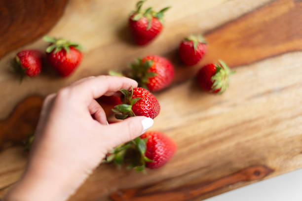 istock Woman hand holding strawberry 2155227211