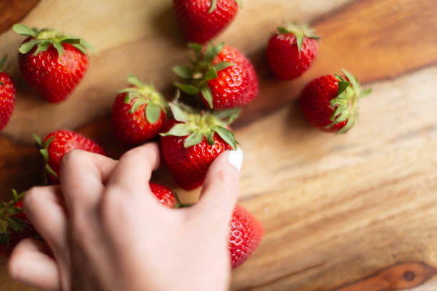 istock Woman hand holding strawberry 2155227804