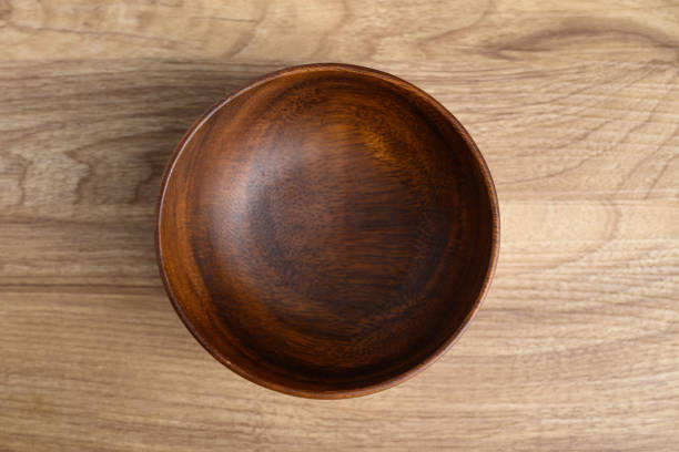 istock A dark wooden bowl on wooden background, Table top view 2155230066