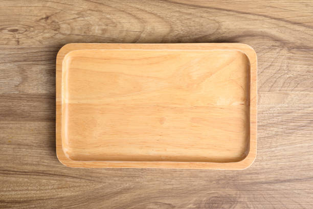 istock A wooden plate on wooden background, Table top view 2155230105