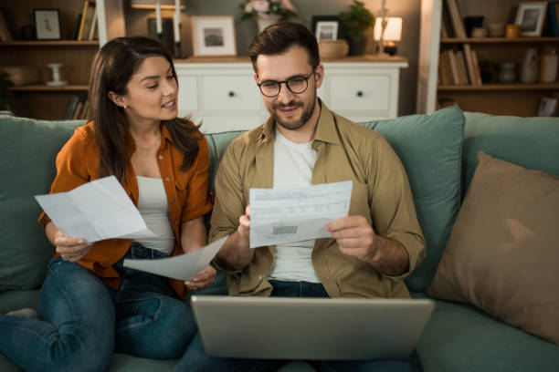 istock Happy couple paying their bills online at home. 2155230621