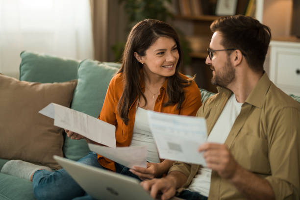istock Happy couple paying their bills online at home. 2155230652