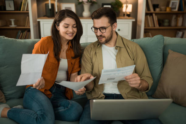 istock Happy couple paying their bills online at home. 2155230668